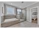 Beautiful bathroom with a soaking tub and glass-enclosed shower featuring tiled walls and marble floors at 1160 Duke Farm Dr, Wake Forest, NC 27587