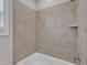 Close up of a white bathtub with tiled walls, complemented by a sleek faucet and a convenient shelf at 1160 Duke Farm Dr, Wake Forest, NC 27587