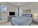 Well-lit bedroom featuring blue bedding, a TV on a dresser, and framed art pieces on the wall at 1160 Duke Farm Dr, Wake Forest, NC 27587