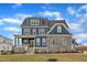 Charming blue two-story home featuring stone accents, a covered porch, manicured lawn, and inviting curb appeal at 1160 Duke Farm Dr, Wake Forest, NC 27587