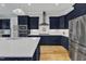 Modern kitchen with stainless steel refrigerator, white marble countertops, and stylish navy blue cabinetry at 1160 Duke Farm Dr, Wake Forest, NC 27587
