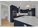 Well-lit kitchen with stainless steel appliances, large island, and navy blue cabinets at 1160 Duke Farm Dr, Wake Forest, NC 27587