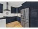 Stylish kitchen with stainless steel refrigerator, range, and dark blue cabinetry at 1160 Duke Farm Dr, Wake Forest, NC 27587