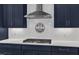 Close-up of a modern kitchen with a cooktop and dark blue cabinetry at 1160 Duke Farm Dr, Wake Forest, NC 27587