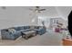 Spacious living room with a large sofa, ceiling fan, and views of exercise equipment and a drum set at 1160 Duke Farm Dr, Wake Forest, NC 27587