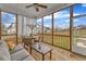 Relaxing screened porch features a ceiling fan, neutral furniture, views of the yard, and a wooden floor at 1160 Duke Farm Dr, Wake Forest, NC 27587