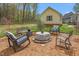 Relaxing outdoor space with a fire pit, seating, and a home surrounded by mature trees at 124 Holly Ridge Ln, Mebane, NC 27302
