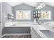 Bathroom showcasing a soaking tub, dual sink vanity, modern fixtures, and a large window with natural light at 124 Holly Ridge Ln, Mebane, NC 27302