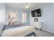 Bedroom boasts a ceiling fan, large TV on dresser, and windows, creating a cozy and inviting atmosphere at 124 Holly Ridge Ln, Mebane, NC 27302