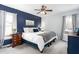 This comfortable bedroom has carpet, a navy accent wall, a ceiling fan, and neutral paint at 124 Holly Ridge Ln, Mebane, NC 27302