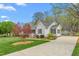Charming single story home with a well-maintained lawn, inviting porch, attractive landscaping and driveway at 124 Holly Ridge Ln, Mebane, NC 27302