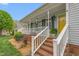 Inviting front porch with brick steps, white railings, and a bright yellow front door at 124 Holly Ridge Ln, Mebane, NC 27302