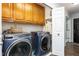 Laundry room with modern washer and dryer units and upper cabinets for storage with access to back door at 124 Holly Ridge Ln, Mebane, NC 27302