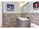 Bathroom with stone accents, white sink and vanity, and a modern light fixture at 125 Long Shadow Pl, Durham, NC 27713