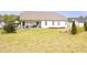 Spacious backyard featuring a lush lawn, trimmed bushes, and patio with a table and chairs at 127 Hurricane Aly, Benson, NC 27504