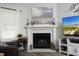 Fireplace with a white mantle, decorative decor, and a mounted television at 127 Hurricane Aly, Benson, NC 27504