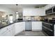 Well-lit kitchen features white cabinets, stainless steel appliances, and decorative backsplash at 127 Hurricane Aly, Benson, NC 27504