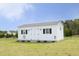 Exterior view of white storage shed featuring double doors, windows with shutters, and decorative details at 127 Hurricane Aly, Benson, NC 27504