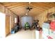Organized shed interior with roll-up door, lawnmower, storage bins, and a high ceiling at 127 Hurricane Aly, Benson, NC 27504