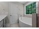 Bright bathroom features a soaking tub with a large window overlooking a beautiful backyard at 128 School Side Dr, Spring Lake, NC 28390
