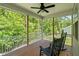 Inviting screened porch with ceiling fan and rocking chairs overlooking lush greenery at 128 School Side Dr, Spring Lake, NC 28390