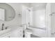 Modern bathroom featuring a shower and bath with subway tile, a round mirror, and sleek fixtures at 129 Burwell Avenue Ave, Henderson, NC 27536