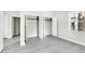 Bedroom featuring neutral paint and grey vinyl flooring with open double closets and multiple doors at 129 Burwell Avenue Ave, Henderson, NC 27536