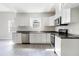 Modern kitchen featuring white cabinets, stainless steel appliances, and hardwood floors at 129 Burwell Avenue Ave, Henderson, NC 27536