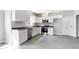 Modern kitchen with white cabinets, stainless appliances, and gray countertop at 129 Burwell Avenue Ave, Henderson, NC 27536