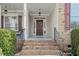 Inviting front porch with brick steps leading to a dark wooden door and decorative wreath at 1312 Golden Bluff Ln, Fuquay Varina, NC 27526