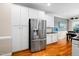 Well-lit kitchen features stainless steel refrigerator and white cabinets at 1312 Golden Bluff Ln, Fuquay Varina, NC 27526