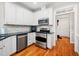 Modern kitchen featuring stainless steel appliances, white cabinets, and wood floors at 1312 Golden Bluff Ln, Fuquay Varina, NC 27526