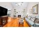 Cozy living room features hardwood floors, fireplace, a ceiling fan and a large window for natural light at 1312 Golden Bluff Ln, Fuquay Varina, NC 27526