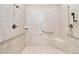Spacious walk-in shower features neutral tile, grab bars, and a shower seat at 1312 Golden Bluff Ln, Fuquay Varina, NC 27526