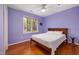 Cozy bedroom with hardwood floors, a large window, and a comfy bed at 1550 Pathway Dr, Carrboro, NC 27510
