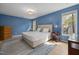 Spacious bedroom with blue walls, neutral accents, tile flooring and ample natural light at 1550 Pathway Dr, Carrboro, NC 27510