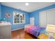 Bright bedroom features blue walls, hardwood floors, and a window view of the outdoors at 1550 Pathway Dr, Carrboro, NC 27510