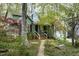 Charming green home with brick pathway, lush landscaping, and inviting front porch at 1550 Pathway Dr, Carrboro, NC 27510