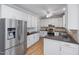 Bright kitchen featuring white cabinets, wood floors, and stainless steel appliances at 1550 Pathway Dr, Carrboro, NC 27510