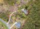 Beautiful aerial shot of the home nestled amongst many trees in a lush landscape and a winding driveway at 160 Sweet Pine Cir, Pittsboro, NC 27312