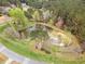 Aerial of pond surrounded by lush trees in established community at 160 Sweet Pine Cir, Pittsboro, NC 27312