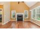 Cozy living room boasts a fireplace, hardwood floors, natural light, and access to the laundry room at 160 Sweet Pine Cir, Pittsboro, NC 27312