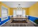 Bright dining room with yellow accent walls, tile floors, and an elegant lighting fixture at 163 Ridge Way Ln, Clayton, NC 27520