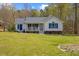 Charming white house with blue accents, a welcoming front porch, and a lush green lawn at 163 Ridge Way Ln, Clayton, NC 27520
