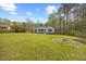Single Gathering home with charming front porch and lush green lawn, nestled in a tranquil wooded area at 163 Ridge Way Ln, Clayton, NC 27520