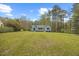 Expansive front yard with a quaint home featuring blue accents, offering serene suburban living at 163 Ridge Way Ln, Clayton, NC 27520