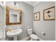 Chic powder room with pedestal sink, decorative mirror, and bee-themed art, adding a touch of elegance at 201 W Amber Oak Drive, Selma, NC 27576