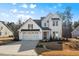 Charming two-story home featuring a pristine white facade, a two-car garage, and a neatly landscaped front yard at 201 W Amber Oak Drive, Selma, NC 27576
