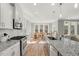Well-lit modern kitchen featuring white cabinets, stainless steel appliances, granite countertops, and a view of the dining area at 201 W Amber Oak Drive, Selma, NC 27576