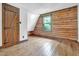 Bright bedroom with wood-paneled walls and ceiling, showcasing a rustic door and original hardwood floors at 207 High House Rd, Cary, NC 27513